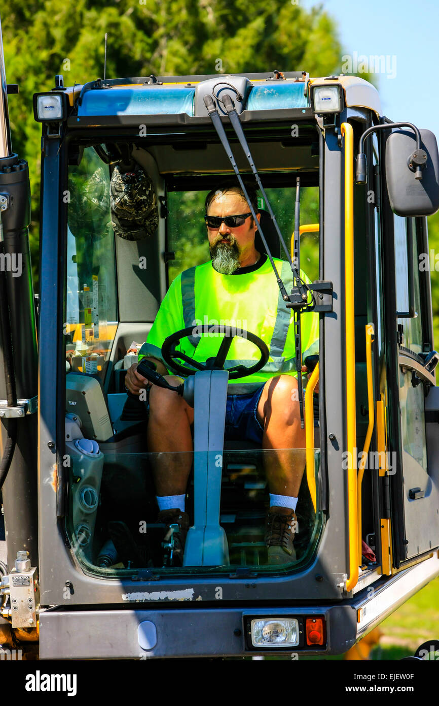 A heavy construction backhoe digger operator in his cab Stock Photo Alamy
