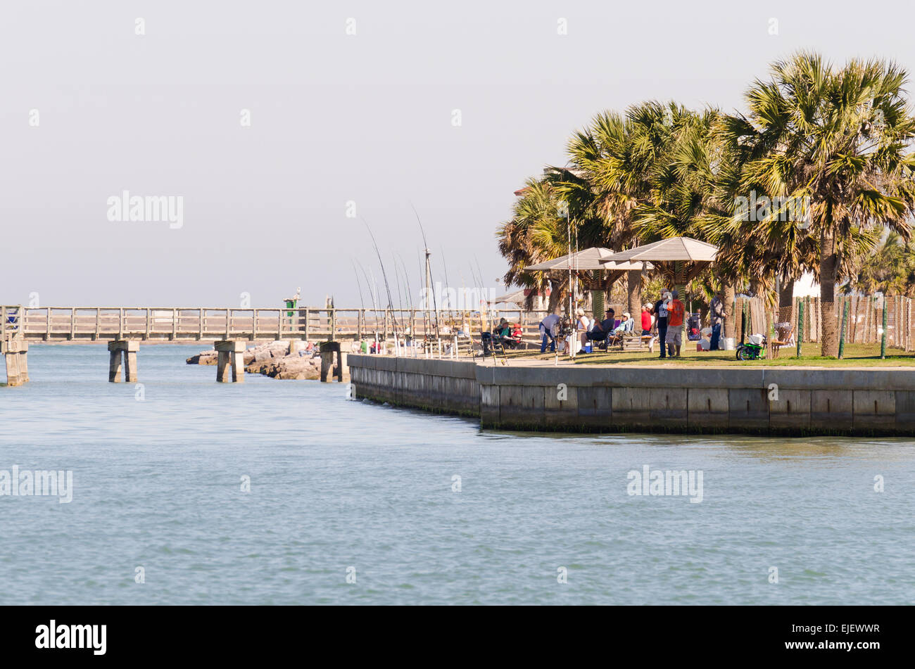 The fishing poles of Retired Senior citizens line the waterfront in Port Aransas Texas Stock Photo