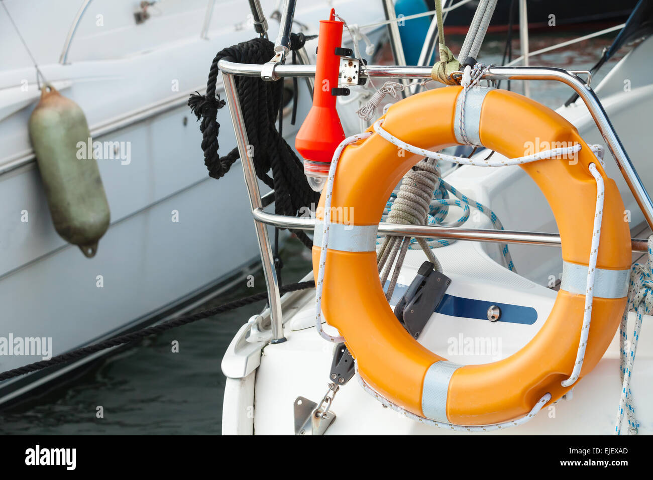 Modern yacht safety equipment, orange lifebuoy mounted on railings