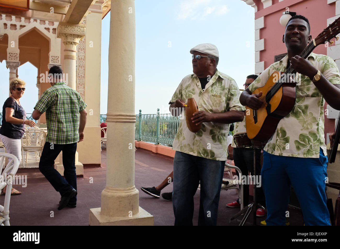 A couple dances to the sound of a live band on the roof of Palacio de Valle in Cienfuegos, on the southern coast of Cuba. Palacio de Valle is an architectural jewel located in the Punta Gorda, reminiscent of Spanish-Moorish art with influences of Gothic, Romanesque and Baroque arts. Stock Photo