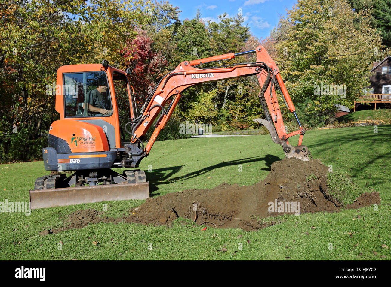 Mini excavator excavates a yard Stock Photo