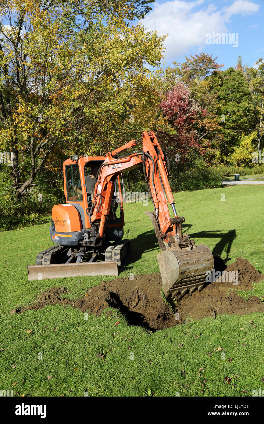 Mini excavator excavates a yard Stock Photo