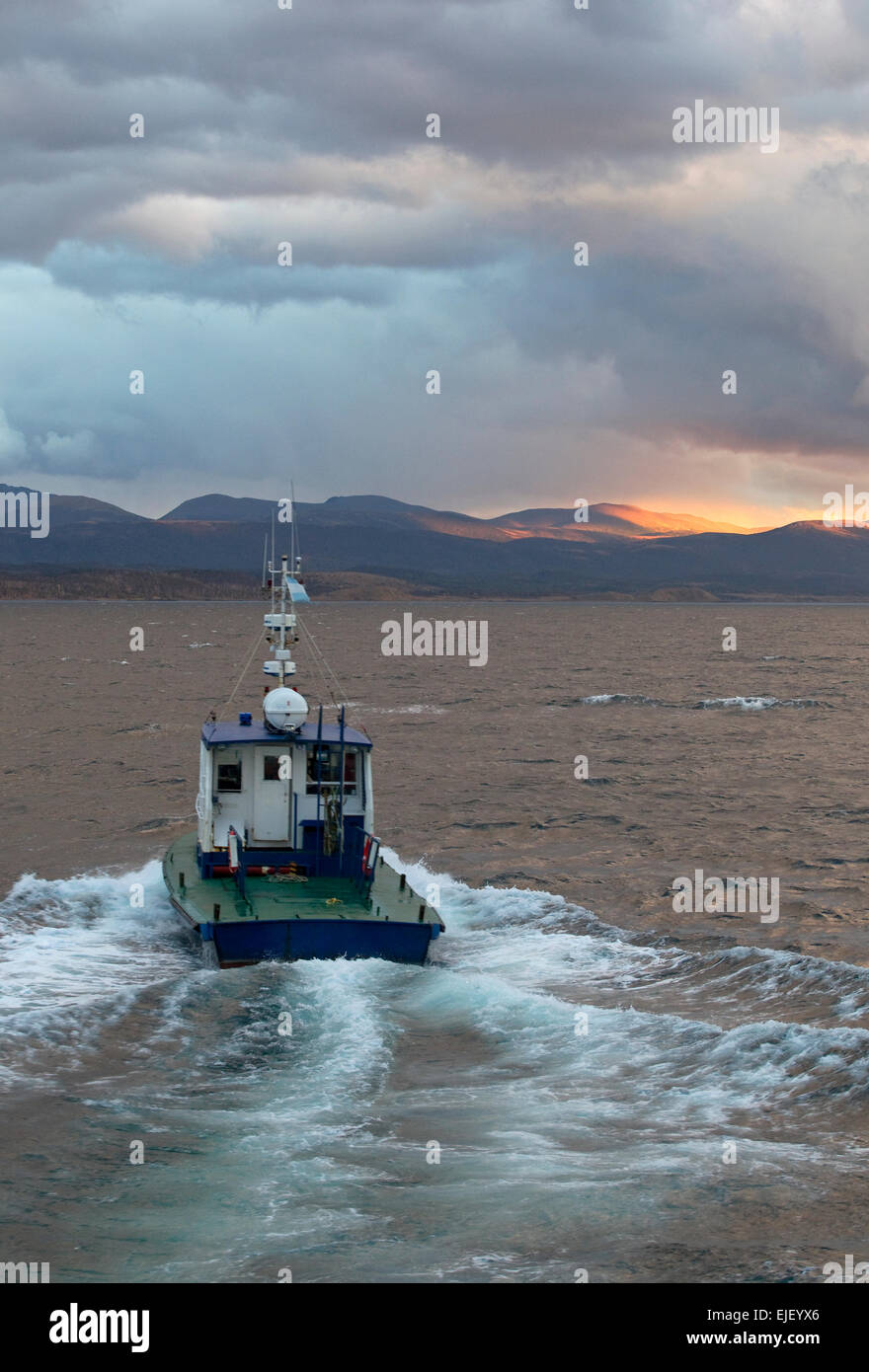 Vessel drives off into the sunset in the Beagle Channel, Terra del Fuego, Argentina Stock Photo