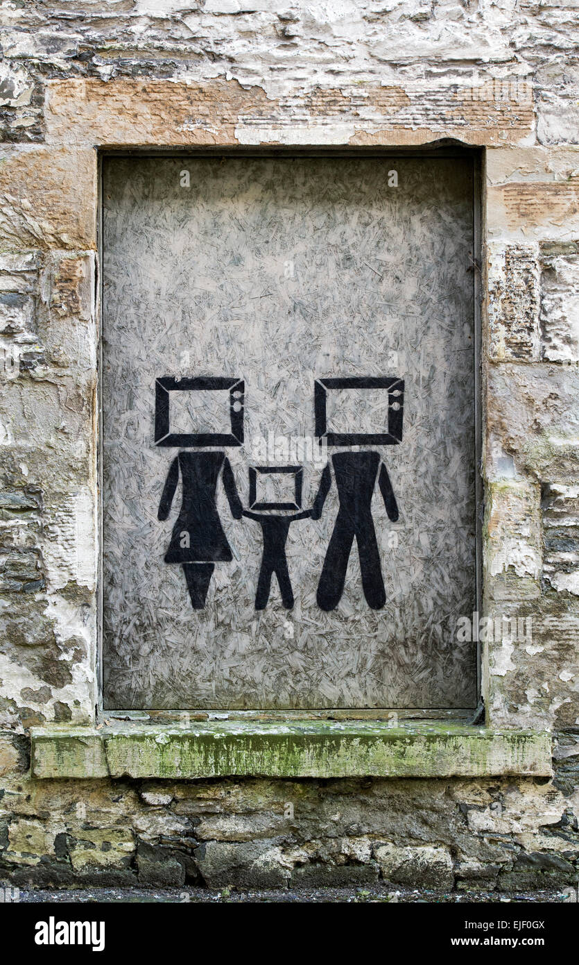 TV head family graffiti on a boarded up window in a old industrial building. An urban statement of a screen culture. Scotland Stock Photo