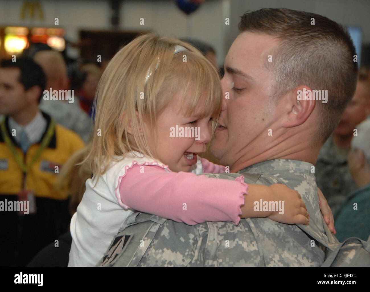 Payton Smoot, 4, clutches her father, 2nd Lt. Robert Smoot of Indianaís 76th Infantry Brigade Combat Team, who just returned from Iraq at the new Indianapolis International Airport on Nov. 12. Soldiers loaded up on buses bound for Camp Atterbury Joint Maneuver Training Center for demobilization processes shortly after the ceremony. Stock Photo