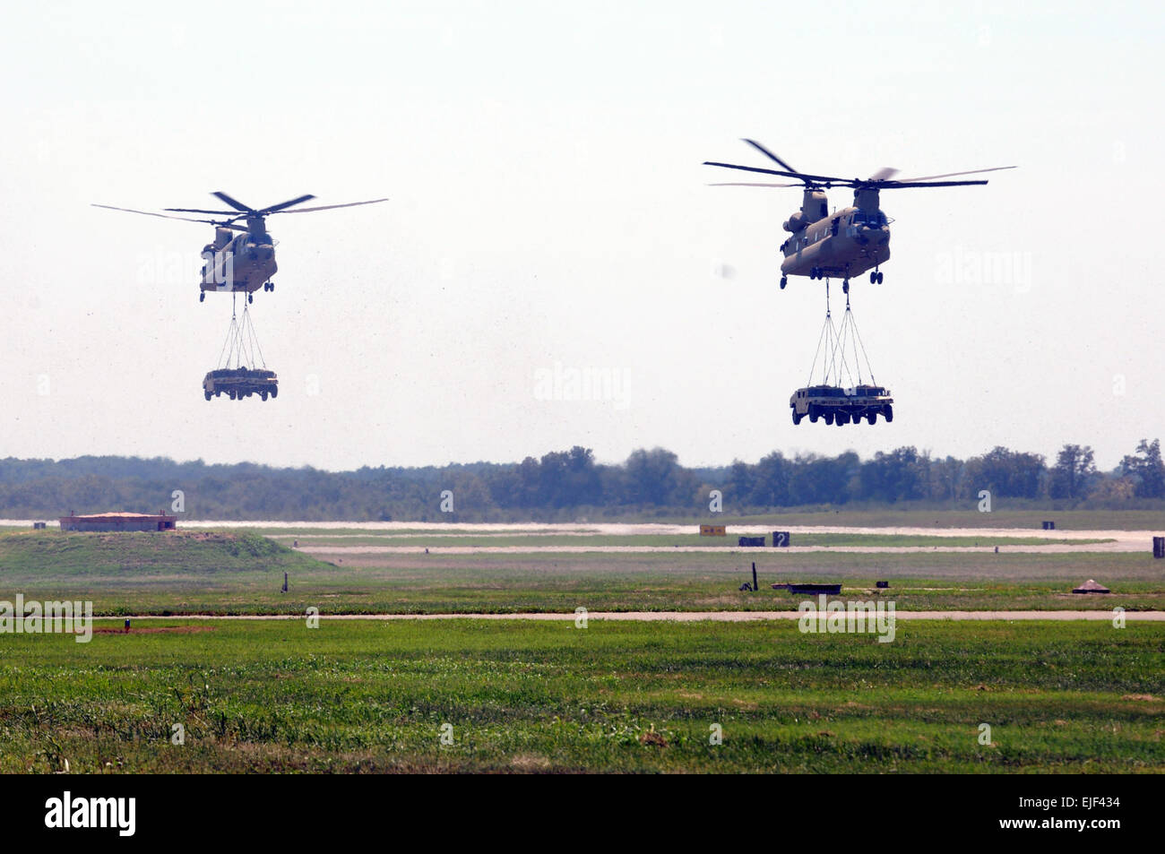 Two CH-47 Chinooks fly over Campbell Army Airfield to drop off two HMMWVs each during an air assault event for the Super Saturday Air Show on Fort Campbell, Ky., Aug. 11. The air show is one of the main attractions during the annual Week of the Eagles, which celebrates the 101st Airborne Division's 70th anniversary and honors its history of valor.  Sgt. Shanika L. Futrell, 159th Combat Aviation Brigade Public Affairs Stock Photo