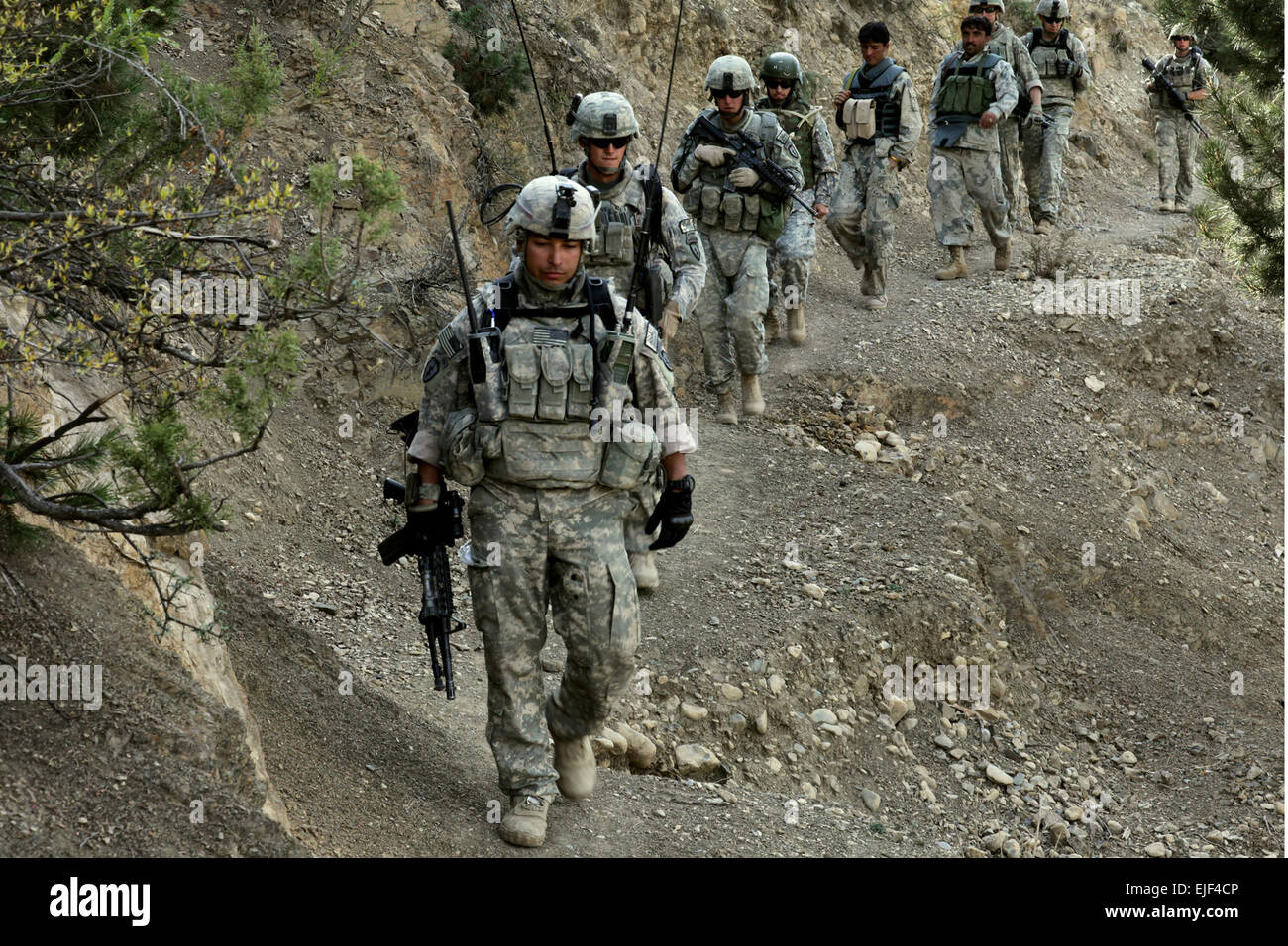 U.S. Soldiers with Apache Troop, 1st Squadron, 40th Cavalry Regiment, and Afghan Border Police walk along a mountain trail during a patrol near Combat Outpost Herrera in the Paktiya province of Afghanistan Oct. 13, 2009.  Army Staff Sgt. Andrew Smith Stock Photo