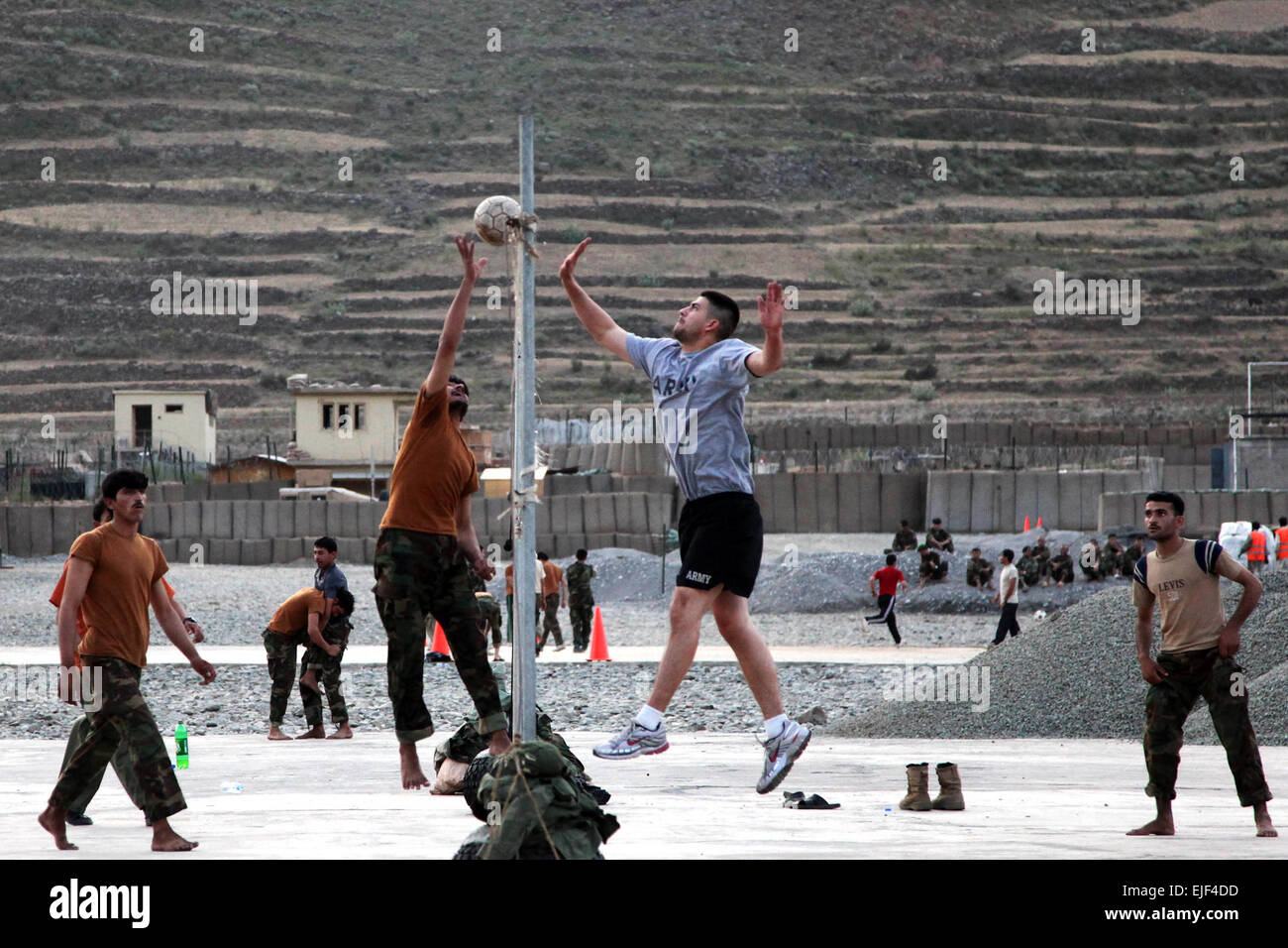 A group of U.S. and Afghan National Security Forces team up to play a game of volleyball at Forward Operating Base Bostick in Kunar province, Afghanistan, July 6. The Soldiers and civilians at the FOB often play sports such as volleyball, soccer and cricket together to build a stronger cohesion.  Staff Sgt. Christopher W. Allison. Stock Photo