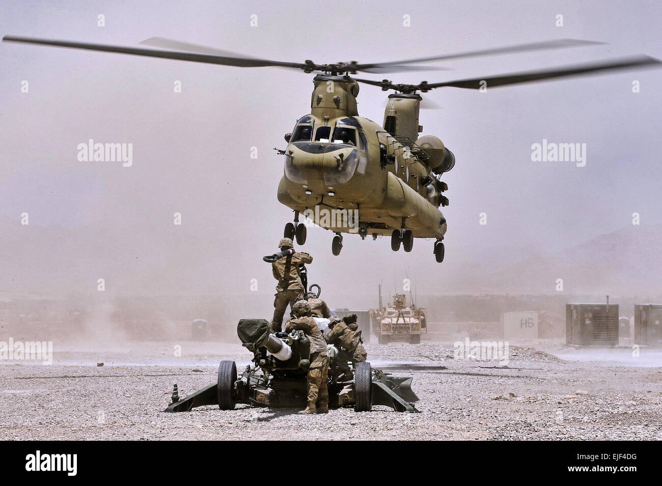 U.S. Soldiers hook-up a M777A2 howitzer to a CH-47 Chinook helicopter to be airlifted from Forward Operating Base Hadrian in Deh Rawud village in Uruzgan province to Kandahar Airfield in Afghanistan’s Kandahar province, June 18, 2013.  Mark Doran Stock Photo