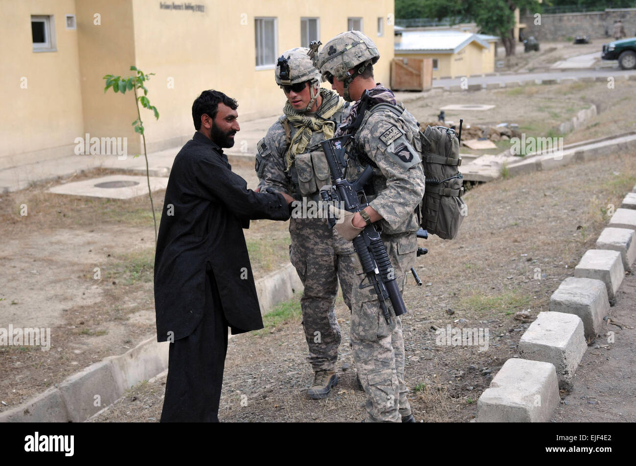 U.S. Army Sgt. Edgar Fierro, of Clarksville, Tenn., a forward observer, and Sgt. Michael S. Lachapelle, of Miami, a team leader, of the 1st Platoon, Charlie Troop, 1st Battalion, 32nd Cavalry Regiment, Task Force Bandit, shake hands with a local Afghan during a visit to an Afghan Border Police station, June 13. Soldiers meet with the ABP several times a week, helping them continue to take a greater lead in providing security for the area.  Spc. Albert Kelley. Stock Photo