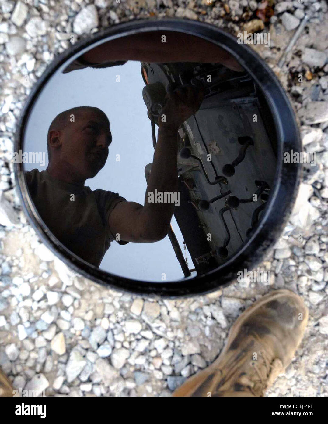 071023-A-3726C-013- The image of Spc. William P. Jones, a light wheel vehicle mechanic from Company B, 173rd Brigade Support Battalion Airborne, reflects in an oil pan as he works on a wrecker in the company motor pool at Forward Operating Base Fenty, Afghanistan on Oct. 23.  2nd Lt. Monika Comeaux Stock Photo