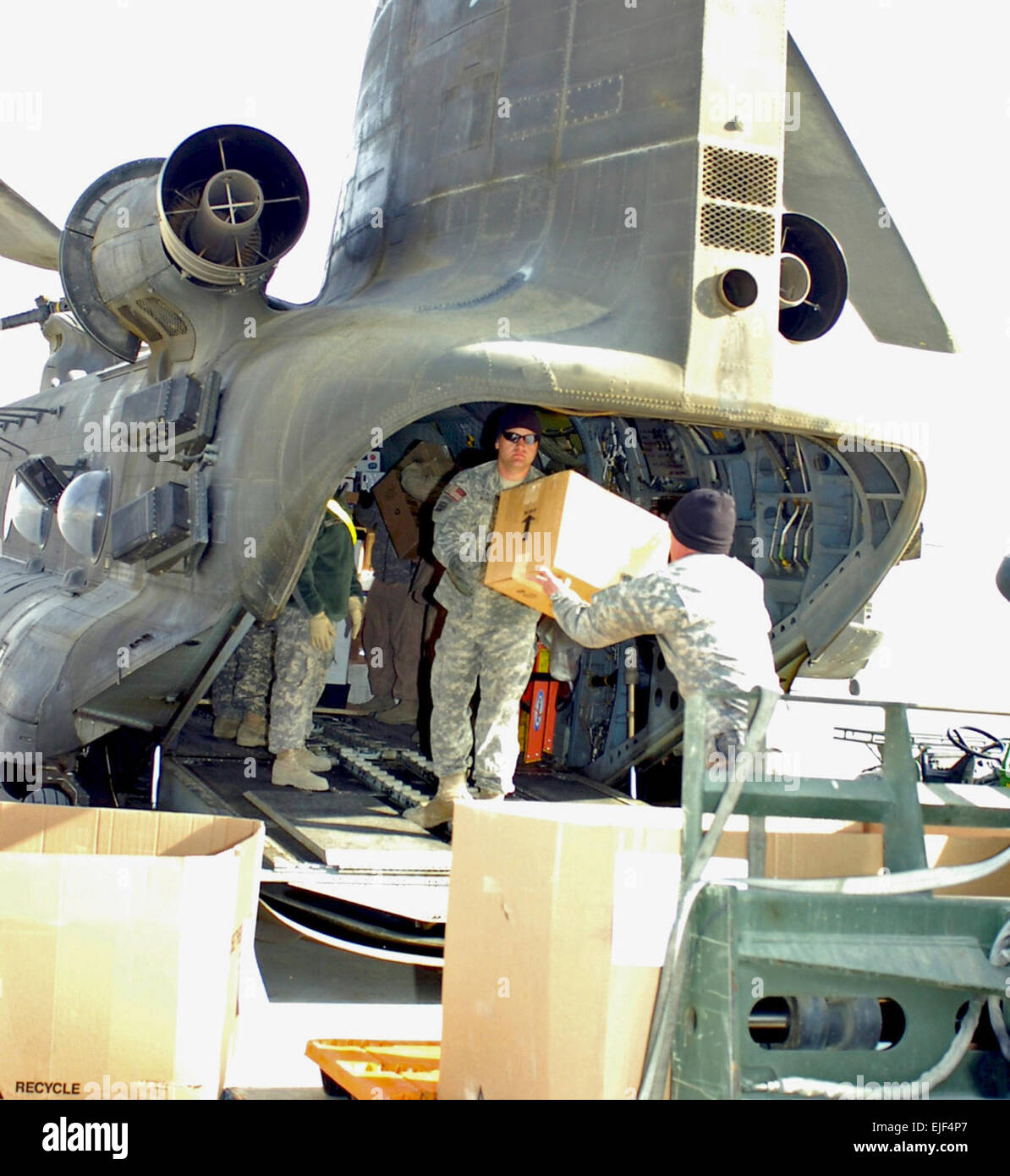 U.S. Army Sgt. Kyle Schonfield passes a box to Spc. Justin Manel while loading mail and packages onto a CH-47 Chinook helicopter Nov. 27, 2007, at Bagram Airfield, Afghanistan. Both Soldiers are with the 485th Postal Company. The helicopter will deliver the mail to service members at forward operating bases and outposts all across the region.  Spc. Aubree Rundle Stock Photo