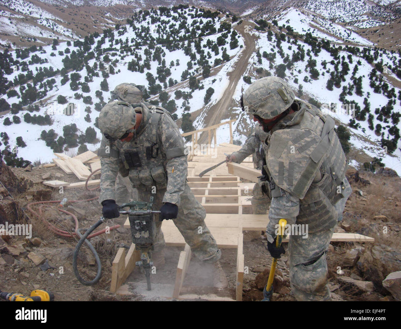Spc. Nathan Waddell and Spc. Kristopher Hammond, Bravo Company, 864th Engineer Battalion, Fort Lewis Wash., work on anchoring the stairwell that will lead to an outpost in the middle of the eastern Afghan mountains. Stock Photo