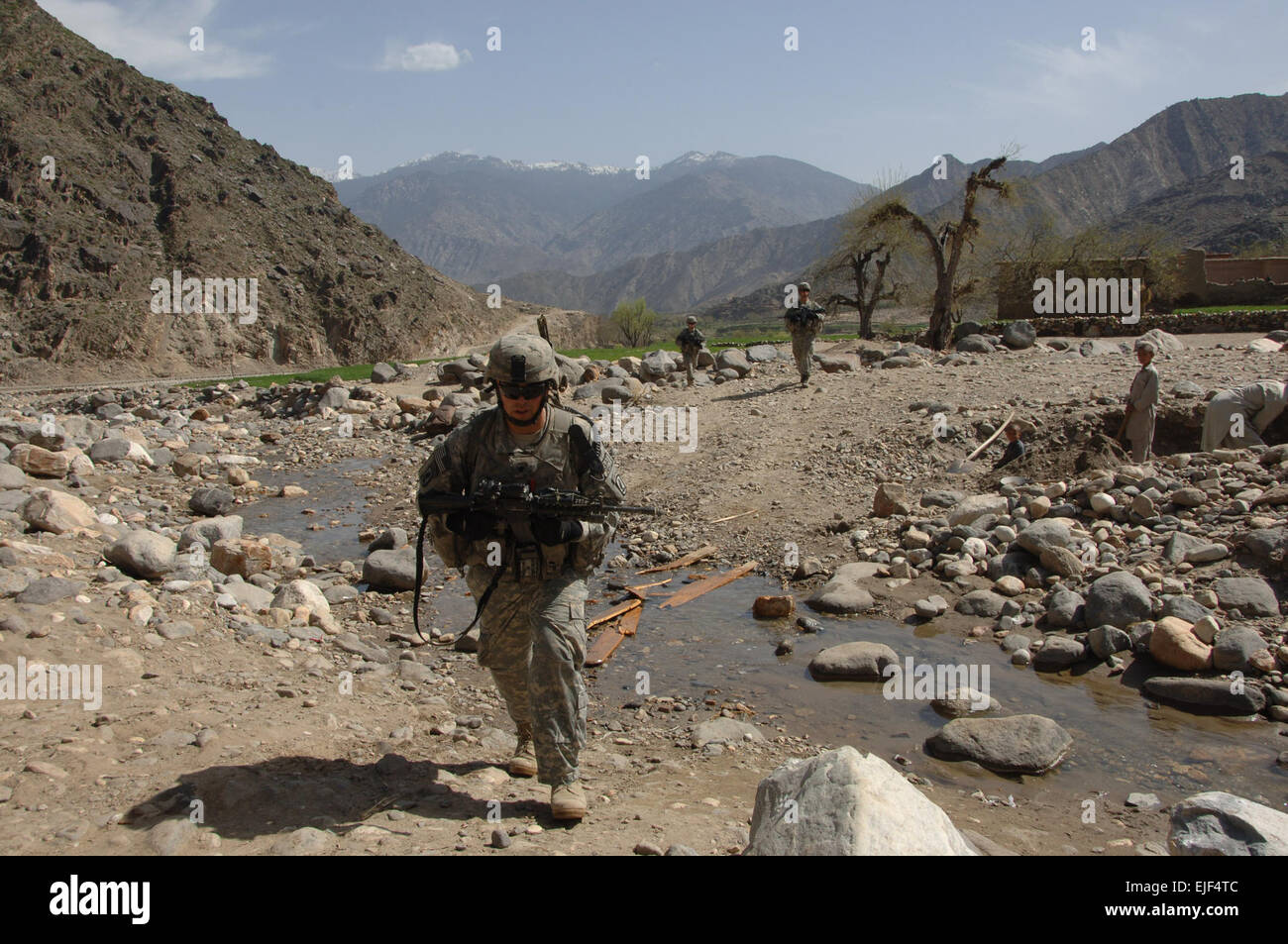 U.S. Army Spc. Gabriel Green crosses a stream while en route to Rechah Lam village in the Kunar province of Afghanistan March 20, 2008. Green is the forward observer for Weapons Squad, 1st Platoon, Chosen Company, 2nd Battalion, 503rd Infantry Airborne, 173rd Airborne Infantry Brigade. Thevillage is known to inhabit suspected anti-Afghan forces.  Staff Segt. Tyffani L. Davis Released Stock Photo