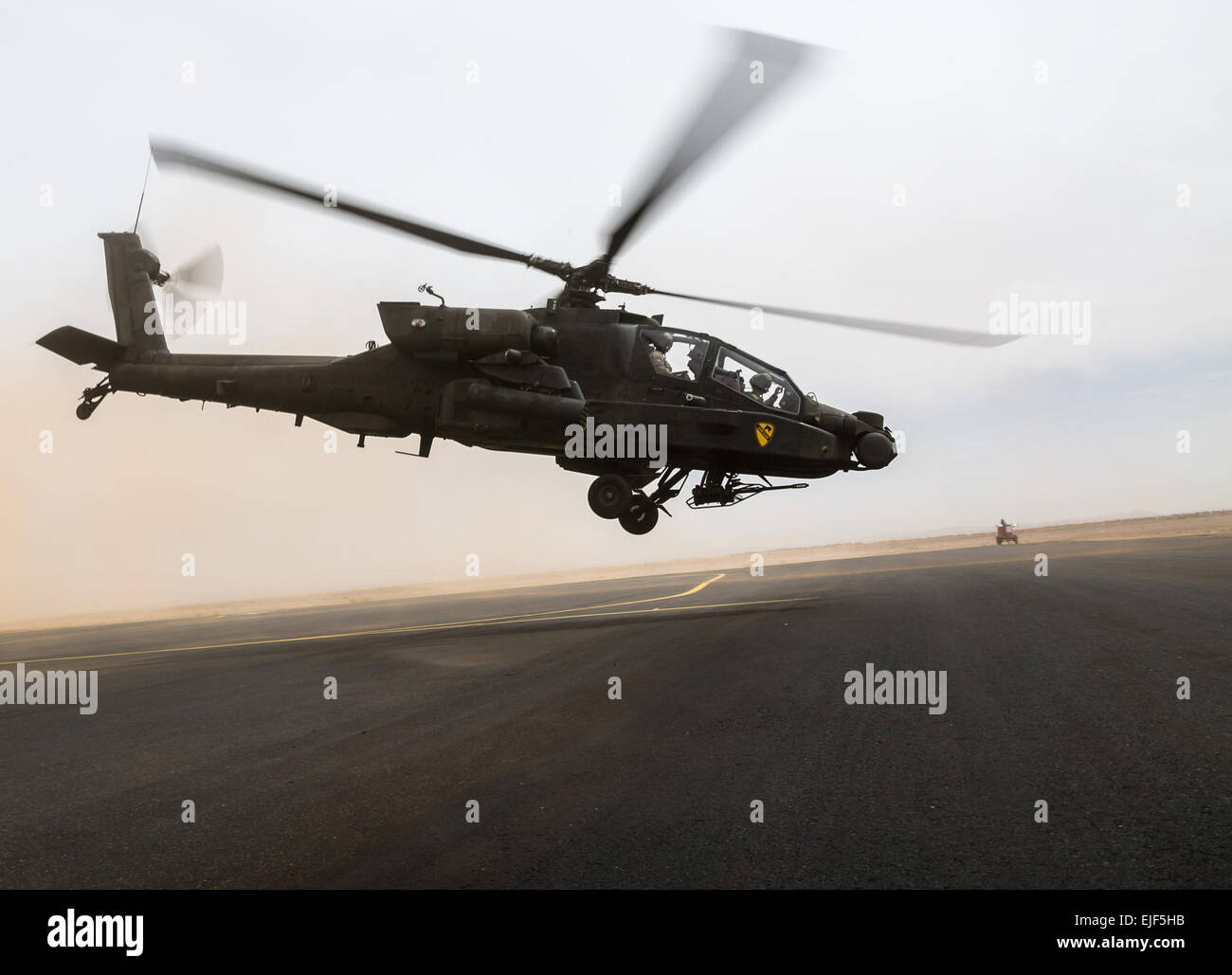 An AH-64 Apache operated by the U.S. Army's 4th Battalion, 227th Attack Reconnaissance Battalion, 42nd Combat Aviation Brigade, and Royal Saudi Land Forces personnel from 1st Battalion, 3rd Aviation Group, takes off at the start of a practice air assault during Exercise Friendship and Iron Hawk 14 on April 12, 2014, near Tabuk, Saudi Arabia. Iron Hawk and Friendship 14 involved U.S. Army forces from the 42nd CAB, New York Army National Guard, and 2nd Brigade Combat Team, 4th Infantry Division, and Saudi Arabian ground and aviation forces. Over weeks of practice the two militaries focused on im Stock Photo