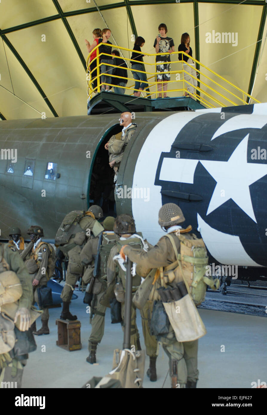 Tourists at the Airborne Museum in Sainte Mere Eglise, France, take  pictures of an exhibit depicting 101st Airborne Division paratroopers  boarding a C-47 aircraft for a jump during the D-Day invasion. Stock Photo