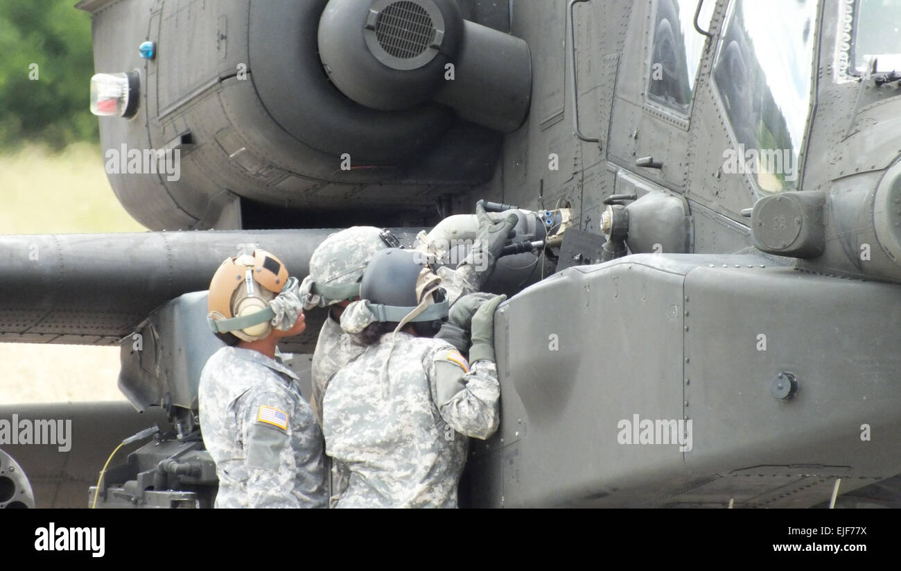 U.S. Soldiers with 2-159th Attack Reconnaissance Battalion, 12th Combat Aviation Brigade, refuel an AH-64D Apache Longbow helicopter July 31, 2013, at the Oberdachstetten Local Training Area forward arming and refueling pad. These petroleum supply specialists practiced setting up their M978 HEMTT fuel tanker and properly prepared the area for aircraft refueling operations. U.S. Army photos by Luis Viegas, Training Support Center Ansbach Stock Photo
