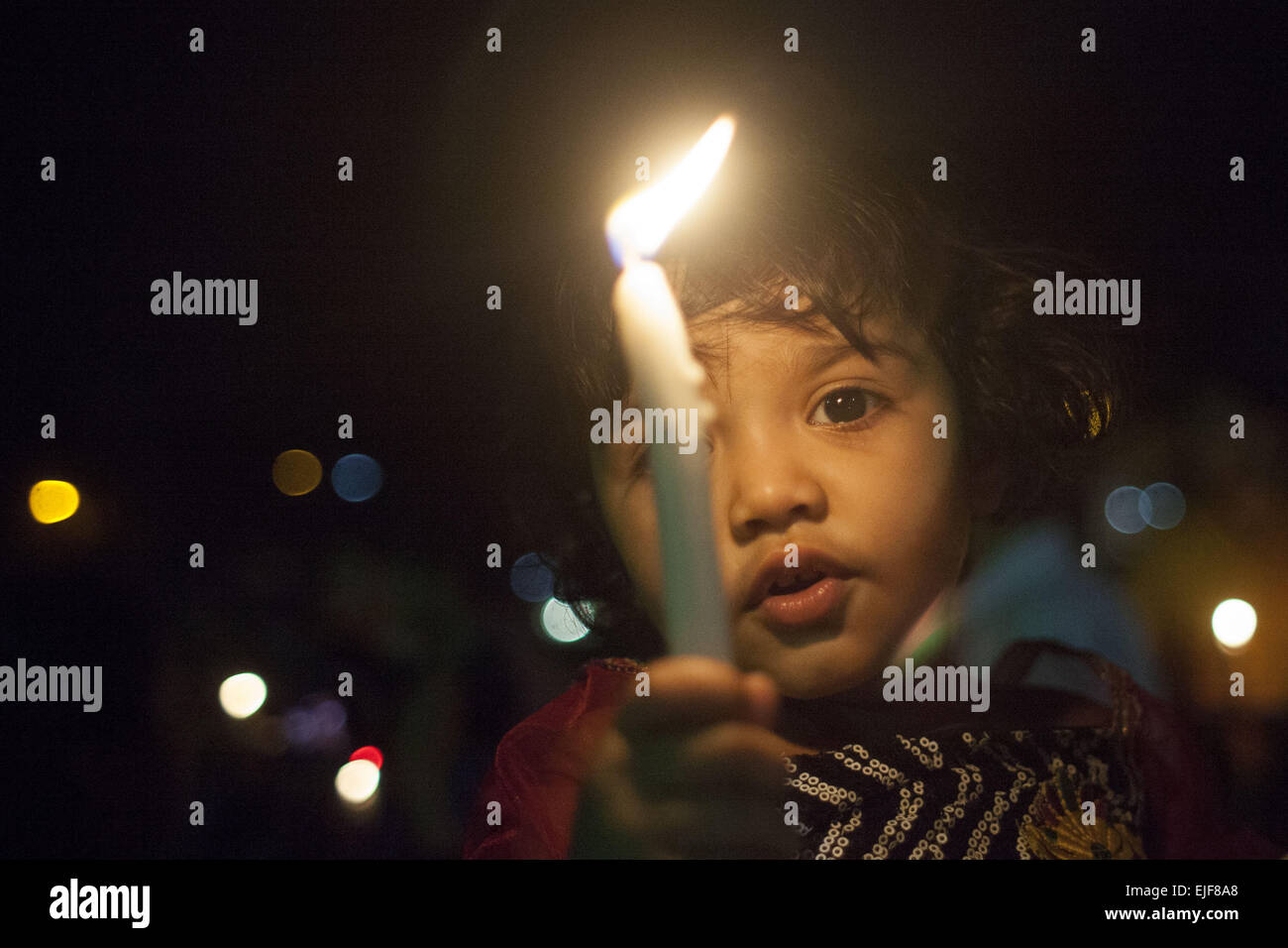 Dhaka, Bangladesh. 25th Mar, 2015. Dhaka, Bangladesh, Wednesday, March 25, 2015 ; A Bangladeshi Child hold candles during a rally in remembrance of those who were killed on this night in 1971, a day ahead of the country's declaration of independence from Pakistan.On this black night in the nationl history, the Pakistani military rulers launched ''Operation Searchlight'' killing some thousand people in that night crackdown alone. As part of the operation, tanks rolled out of Dhaka cantonment and a sleeping city woke up to the rattles of gunfire as the Pakistan army attacked the halls at Dh Stock Photo