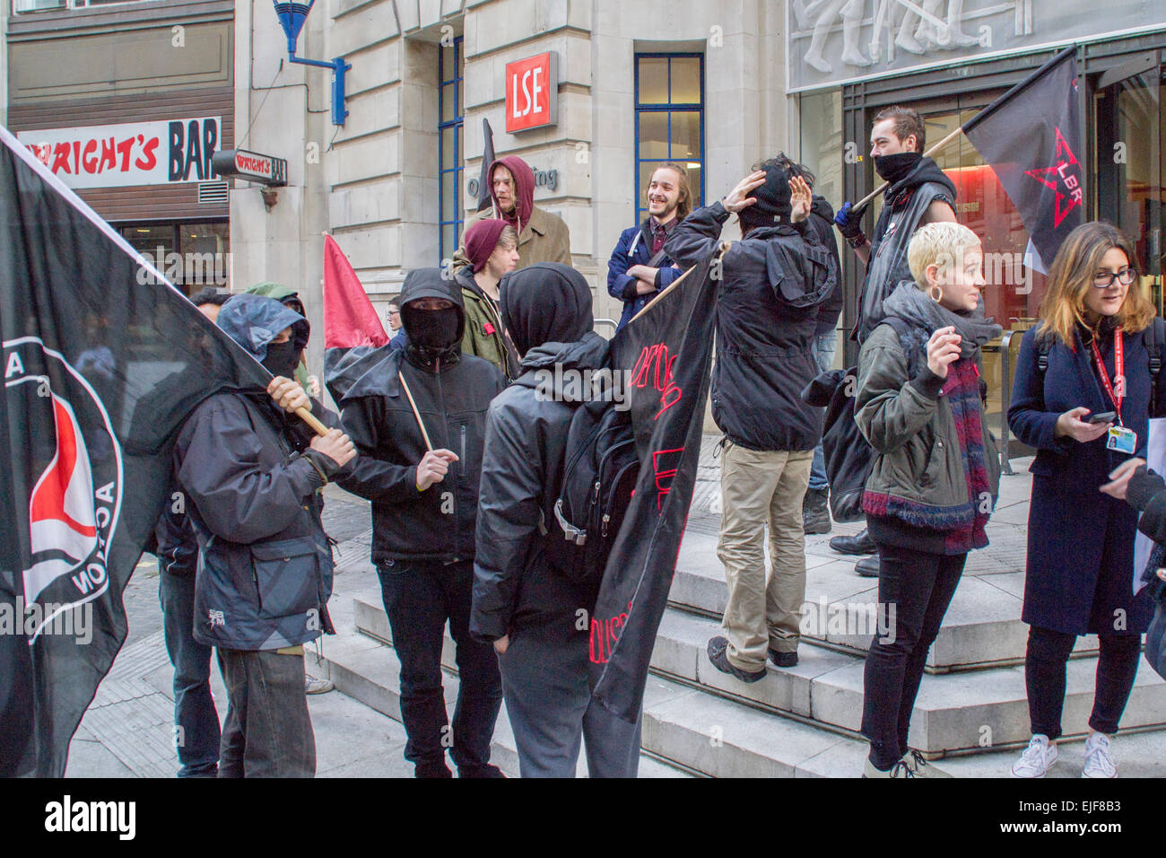 Houghton Street, London, UK - 25th March 2015: Protesters dressed in black outside the LSE Old Building at the start of the Stop The Cuts march from London School of Economics to the London College of Communication in Elephant and Castle. Stock Photo