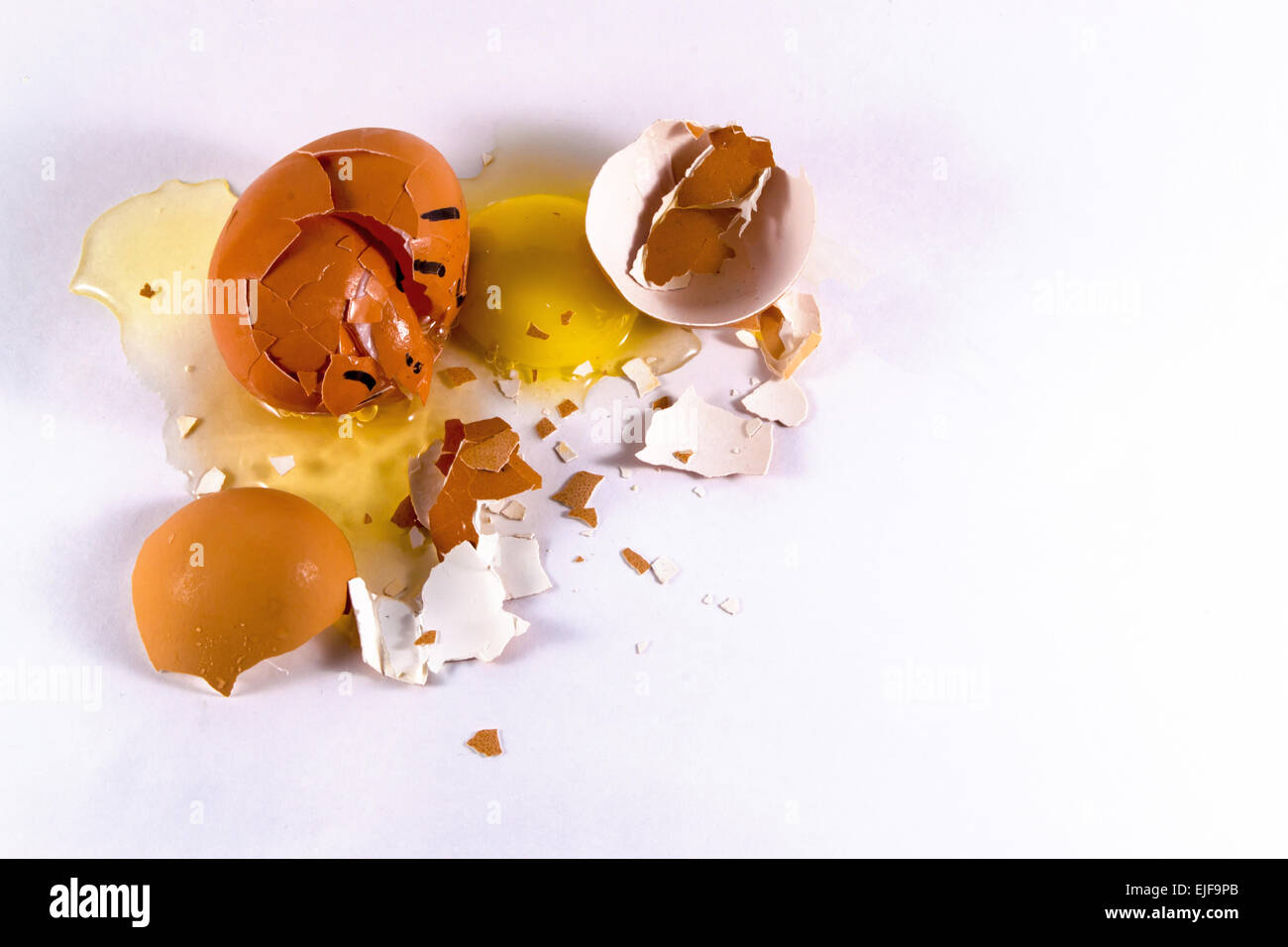 A crushed egg with a face lies amoungst broken shells egg yolk and