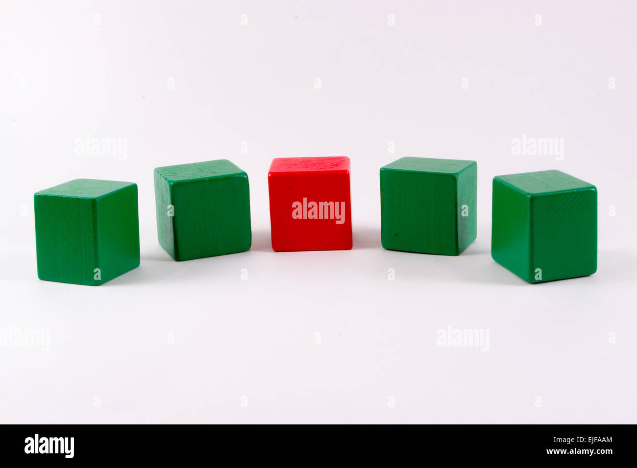 4 green wood building cubes for kids and 1 red one Stock Photo