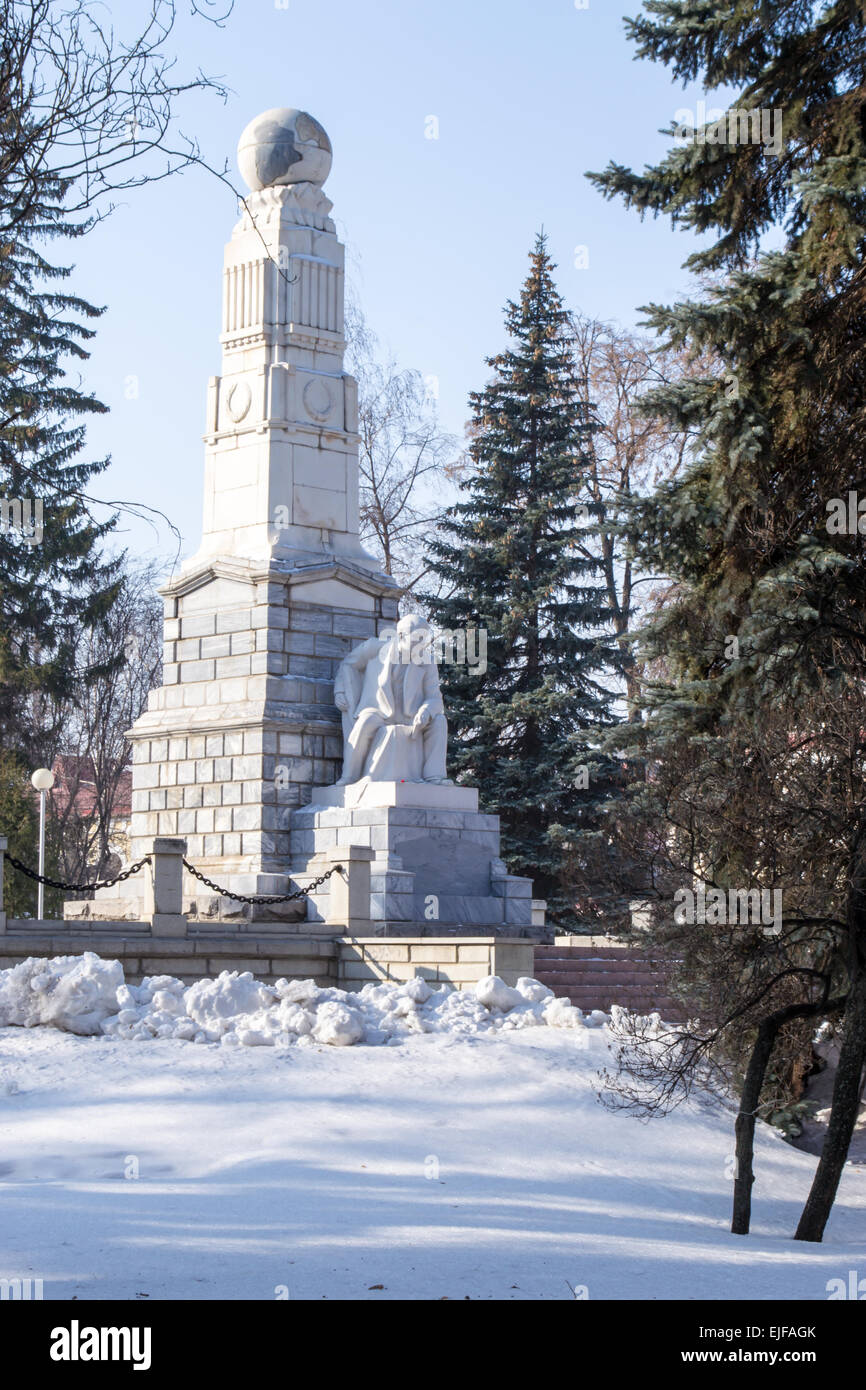 A white Lenin statue in a  winter park with trees and snow Stock Photo