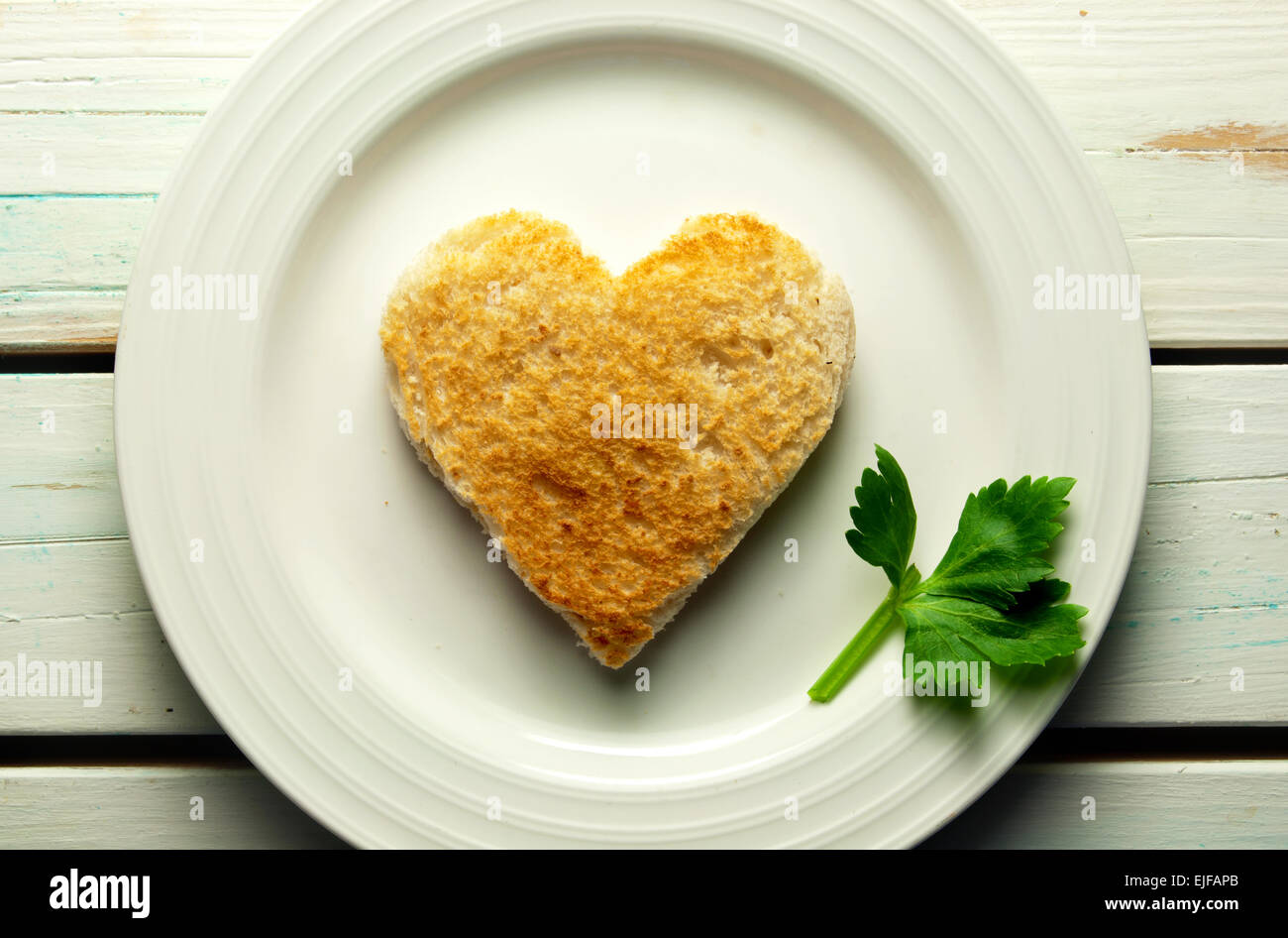 Heart shape toast on a plate with celery leaf Stock Photo