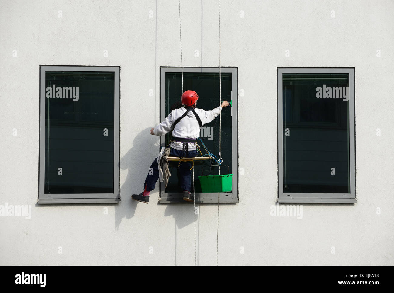 Window washer, cleaning outside on a office building. Stock Photo