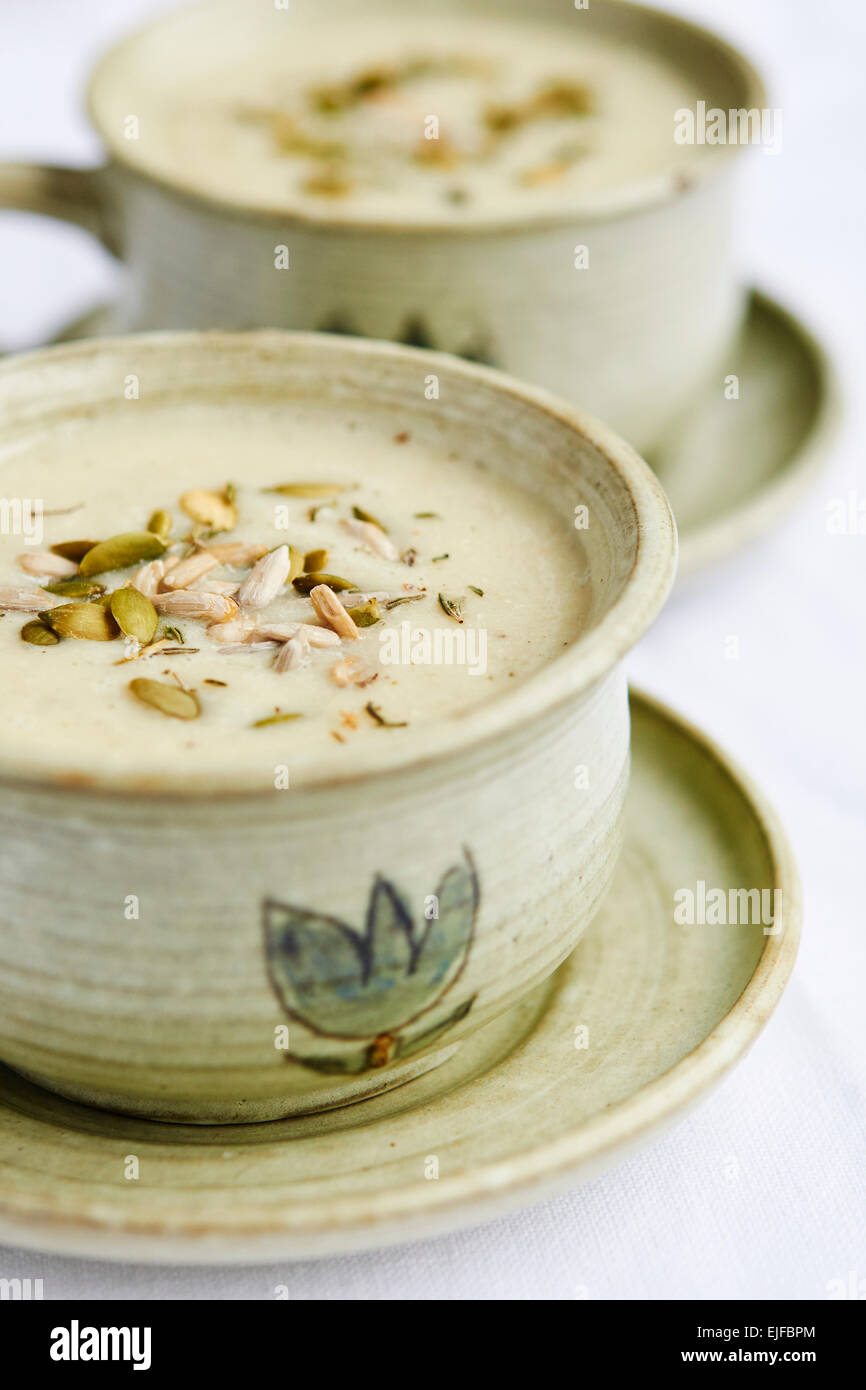 Cup of soup with sunchokes (helianthus tuberosus), celery root, onion and soy cream. Stock Photo
