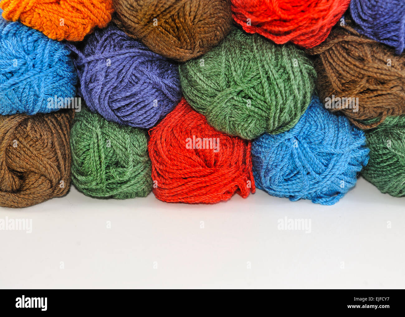 Multi-colored skeins of yarn for knitting stacked one upon the other. Stock Photo