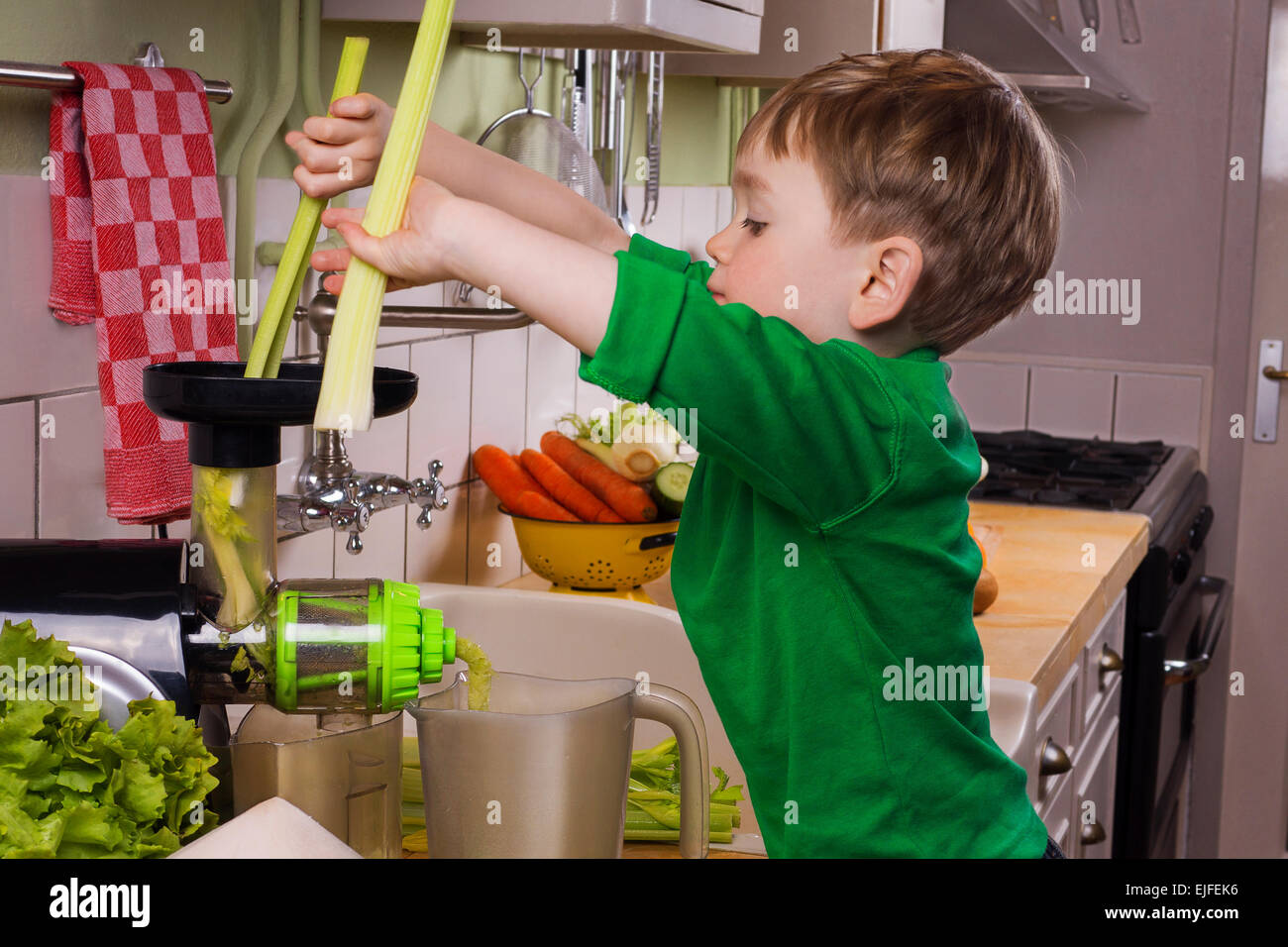 Little boy making green juice Stock Photo