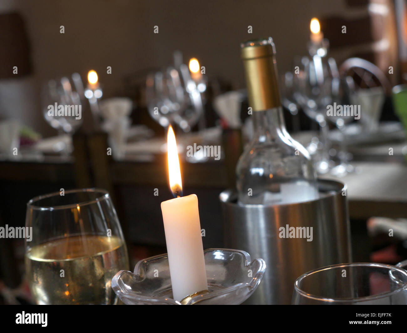 Table setting with textured wine glasses, candles and leaves. Stock Photo  by puhimec