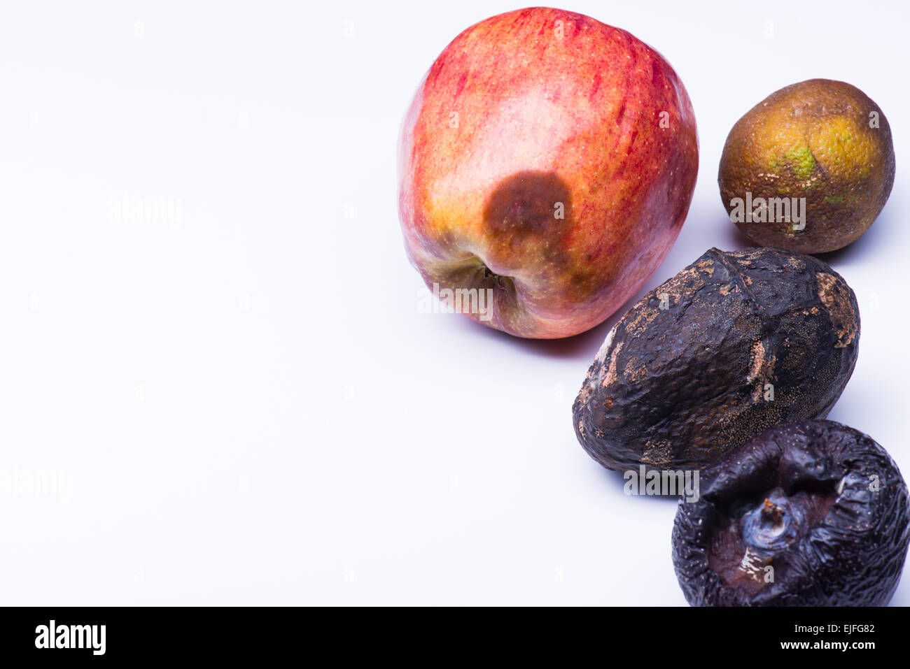 Spoiled fruits isolated on white. Apple, mango, lime, plum Stock Photo