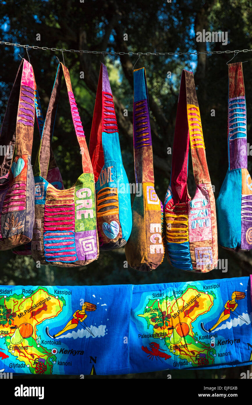 Brightly coloured souvenirs and gifts - handbags, towels with maps -  hanging up for sale at stall at Paleokastritsa, Corfu, Gre Stock Photo