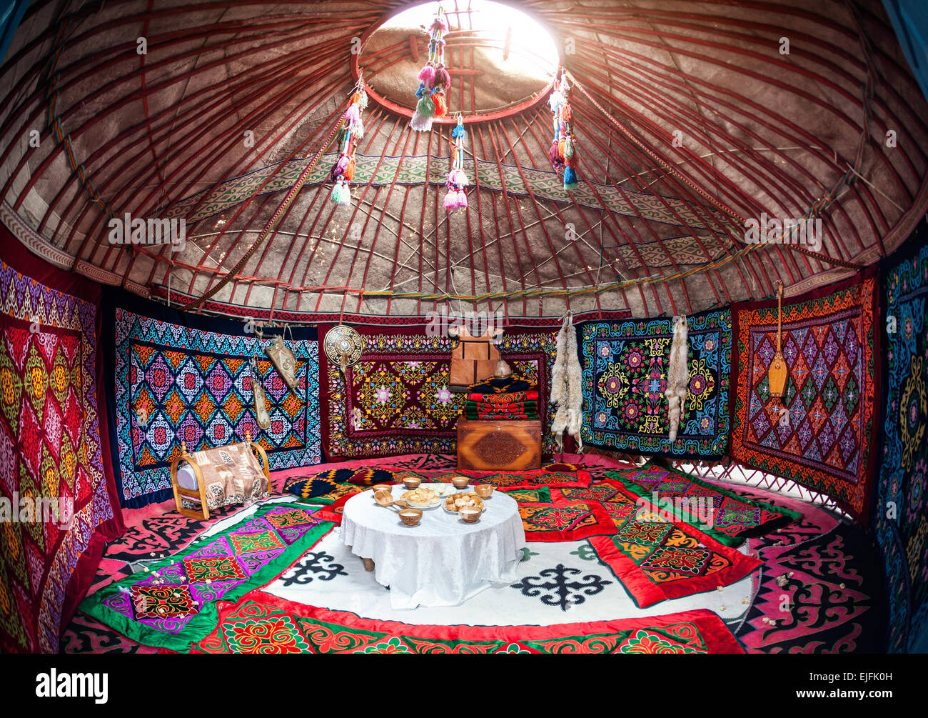 Ethnic nomadic house yurt interior with table of national food at Nauryz celebration Stock Photo