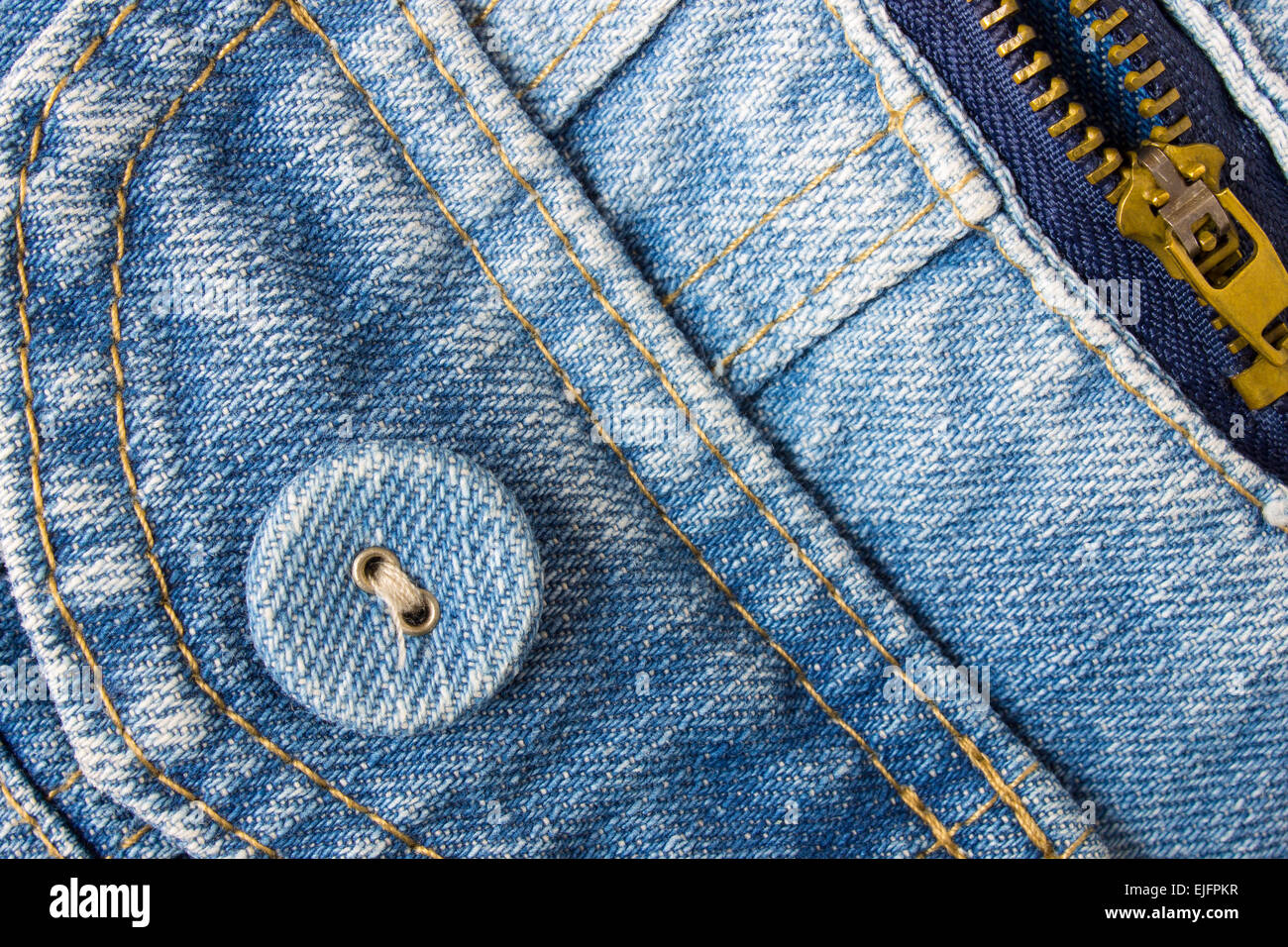 Jeans button bottom left corner with part of pocket and zip on pale blue  jeans fabric. Jeans style for fashion design Stock Photo - Alamy