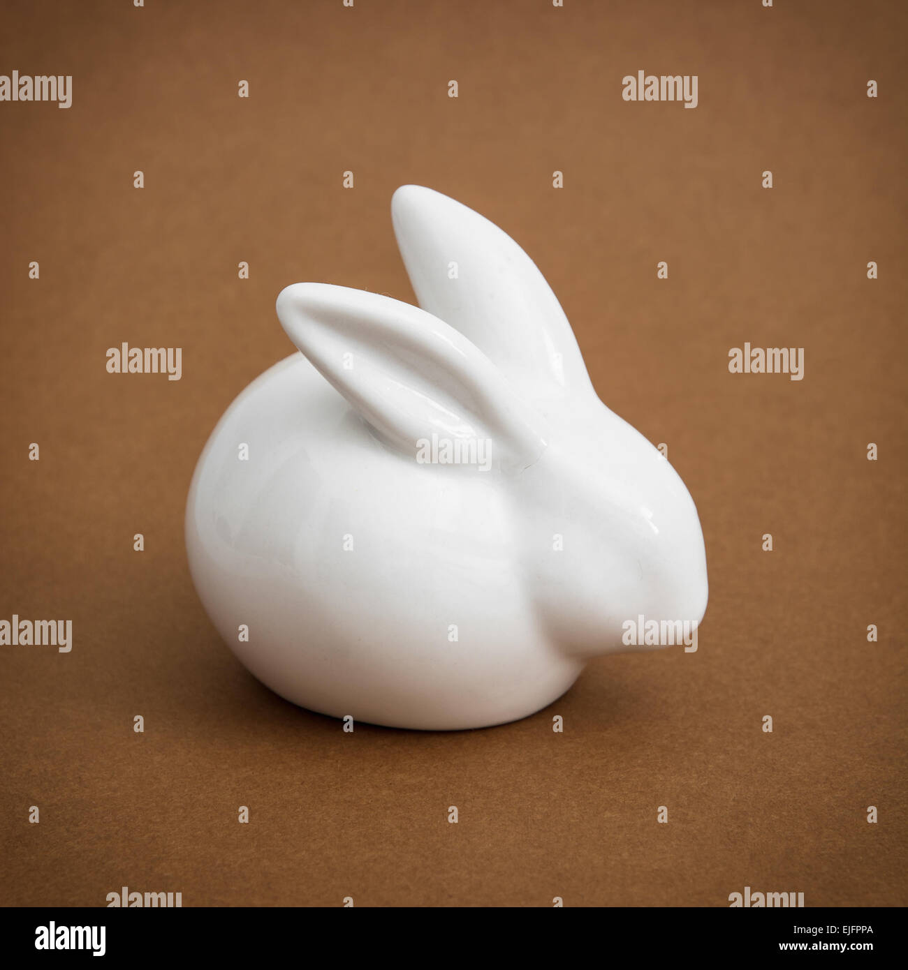 White ceramic easter bunny on the brown background Stock Photo - Alamy