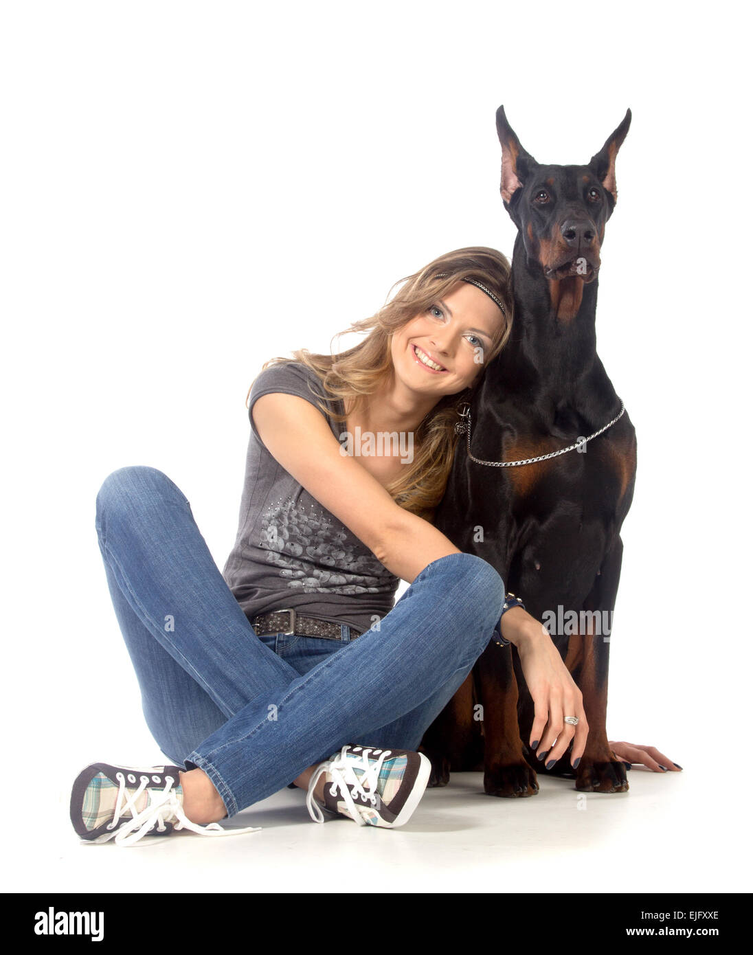 Young woman with black dobermann dog, isolated on white Stock Photo