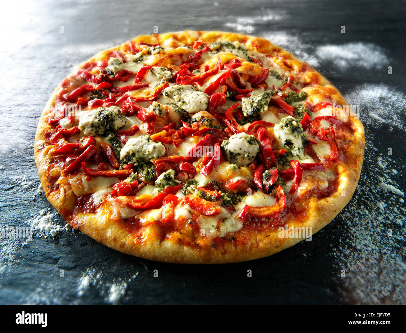 Whole Pizza topped with pesto  chicken and red peppers Stock Photo