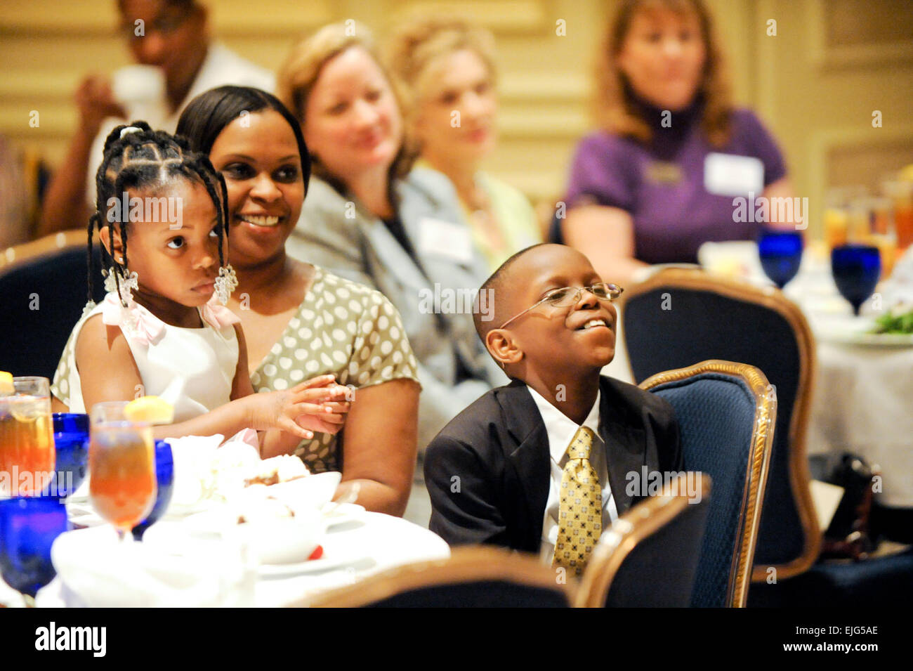 Willie Banks III, right, attends a luncheon in Crystal City, Va., April 8, where he was recognized as the 2010 Operation Homefront Military Child of the Year, while his mother, Felicia, and his younger sister Lynn look on.         Military Child of Year learns life lessons from late father   /-news/2010/04/30/38245-military-child-of-year-learns-life-lessons-from-late-father/index.html Stock Photo