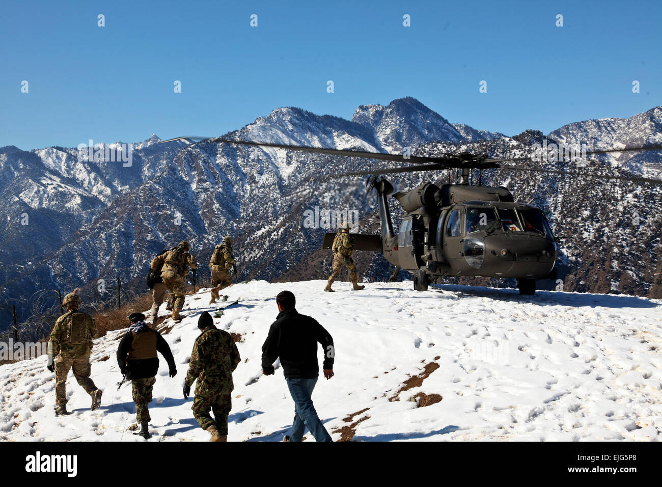 U.S. Soldiers of Headquarters and Headquarters Company, 2nd Battalion, 27th Infantry Regiment, 3rd Brigade Combat Team, 25th Infantry Division, and Afghan National Army Soldiers, prepare to board a U.S. Army UH-60 Black Hawk helicopter, at Observation Post Mangol, Feb. 8, 2012, in the Nari district, Kunar province, Afghanistan. Stock Photo