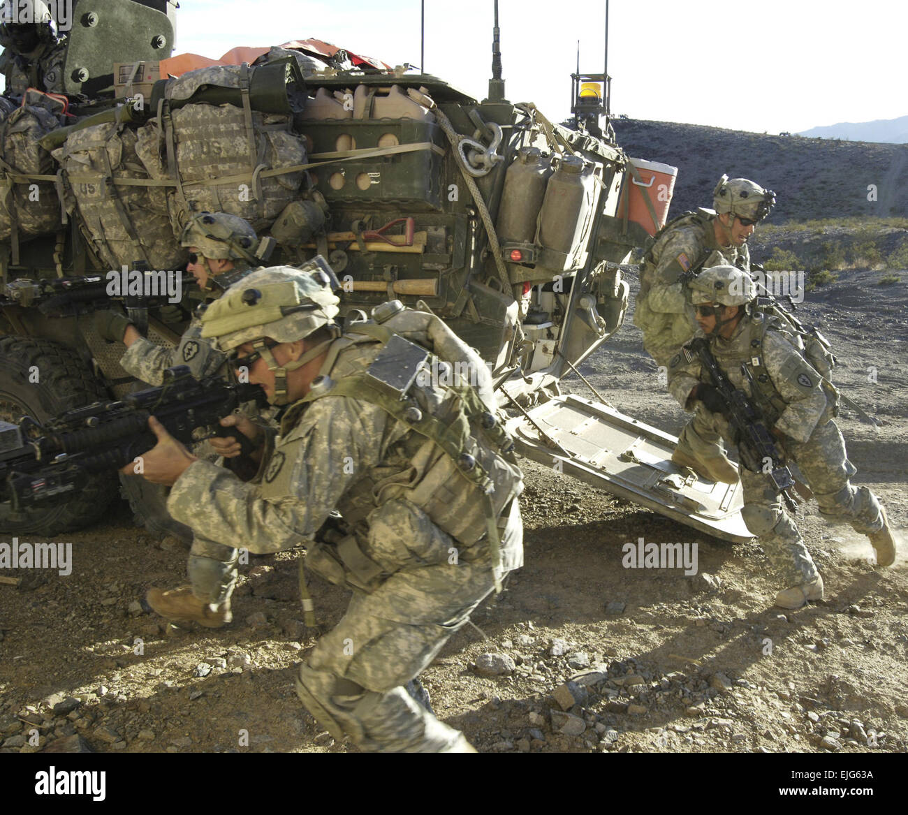 U.S. Army Soldiers from 25th Infantry Division out of Schofield Barracks, Hawaii, charge out of the back of a Stryker vehicle during a training exercise at Fort Irwin, Calif., Sept. 25, 2007. The Soldiers are training for their upcoming deployment to Iraq.  Spc. Tiffany Dusterhoft Stock Photo