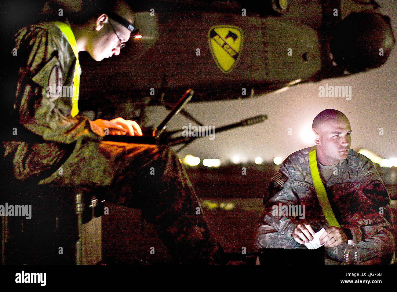 Working under a night sky, U.S. Army Sgt. Derrick Douglas, right, and Spc. Nicholas Kirckof, left, review aircraft logs to plan the night's work load on Camp Beurhing, Kuwait, May 5, 2009. Douglas and Kirckof, both AH-64D Apache attack helicopter crew chiefs, are assigned to the 1st Cavalry Division's Company B, 4th Attack Reconnaissance Battalion, 227th Aviation Regiment, 1st Air Cavalry Brigade. Sgt. Travis Zielinski Stock Photo