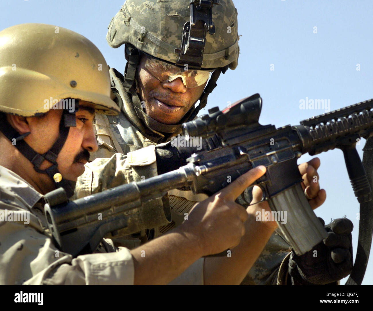 Staff Sgt. Jesse Linen, 1st Brigade Combat Team, 1st Armored Division, shows a member of the Iraqi Army the functions of the M-4 assault rifle during joint weapons training in Tal Afar, Iraq on May 18, 2006.  The purpose of the training was two-fold, allowing both U.S. and Iraqi forces to familiarize each other on various weapons systems, and developing espirit de corps amongst both armies.  Staff Sgt. Jacob N. Bailey.      . Stock Photo