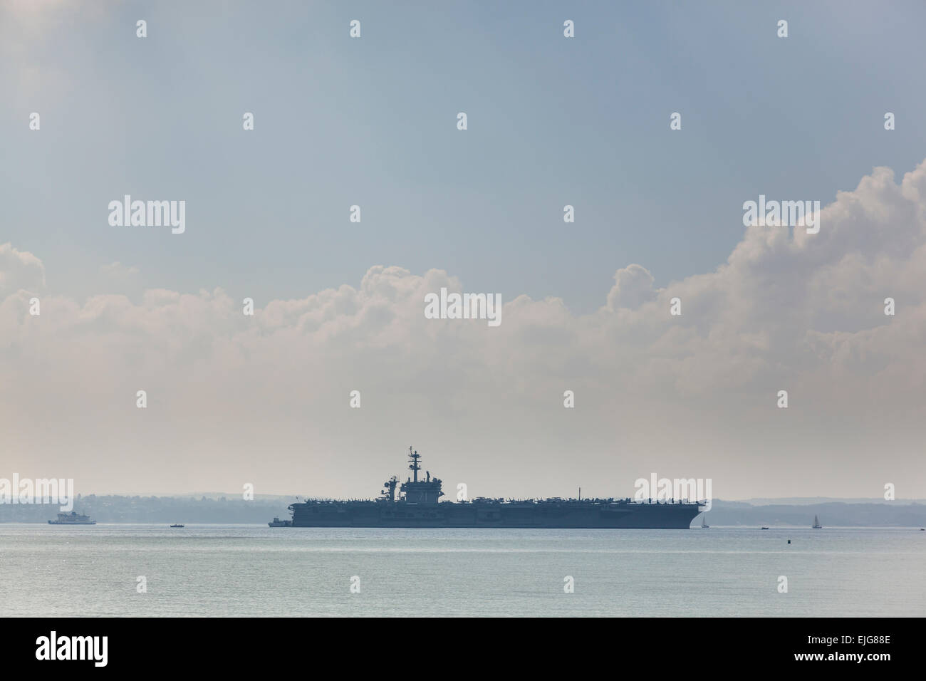 Stokes Bay, Solent, UK. 25th March, 2015. The Nimitz class aircraft carrier USS Theodore Roosevelt at anchor in Stokes Bay in the Solent, 25th March 2015. Credit:  Anthony Hatley/Alamy Live News Stock Photo