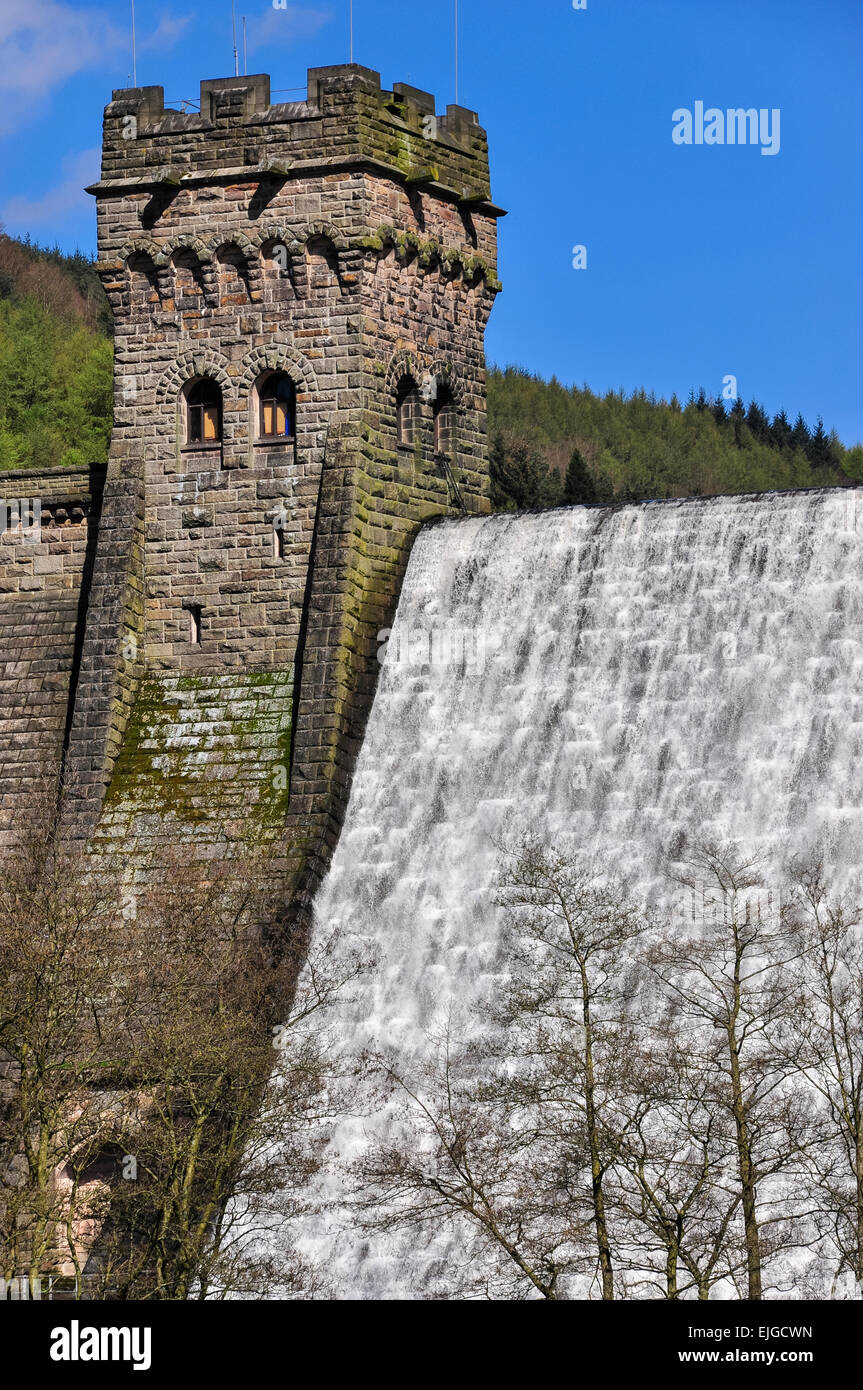 Stone tower at Derwent dam with water cascading over the dam wall. Peak District, Derbyshire. Stock Photo