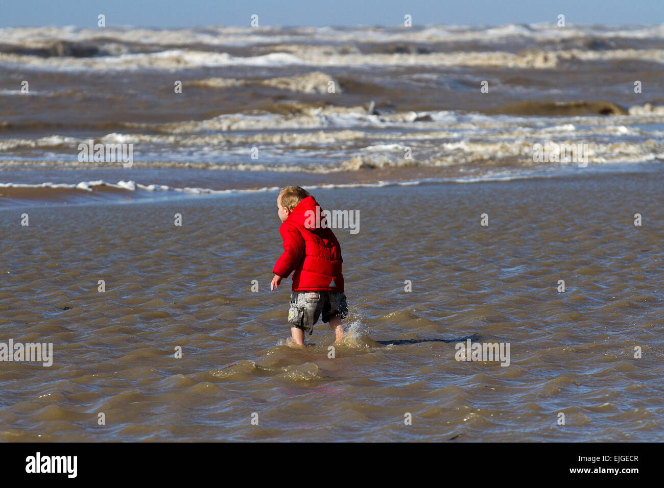 Southport, Merseyside, UK. 26th March, 2015. UK Weather: High Tides & High Winds at Ainsdale. Little boy, 4 years old, enjoying a paddle in the incoming tide from the Irish Sea on the west coast.  Credit:  Mar Photographics/Alamy Live News Stock Photo