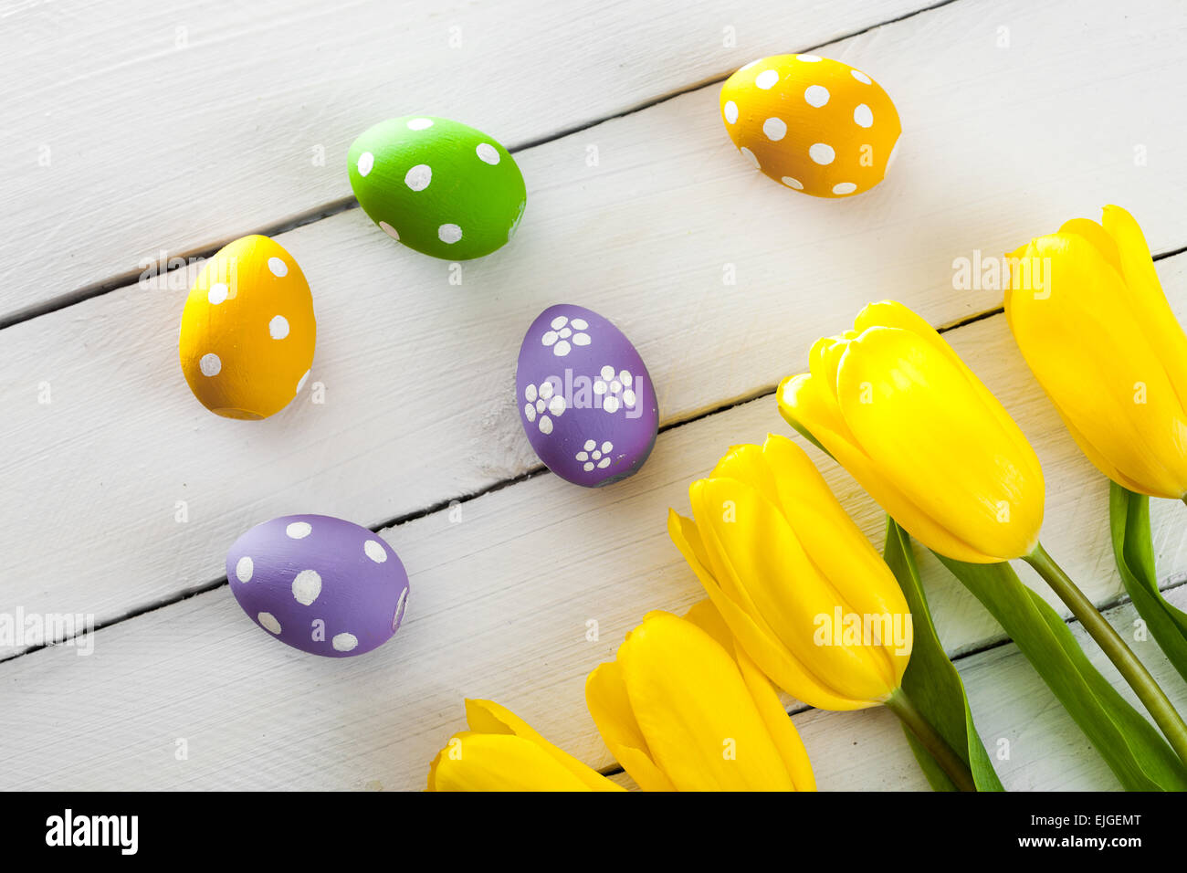 Easter background with colorful eggs and yellow tulips Stock Photo - Alamy