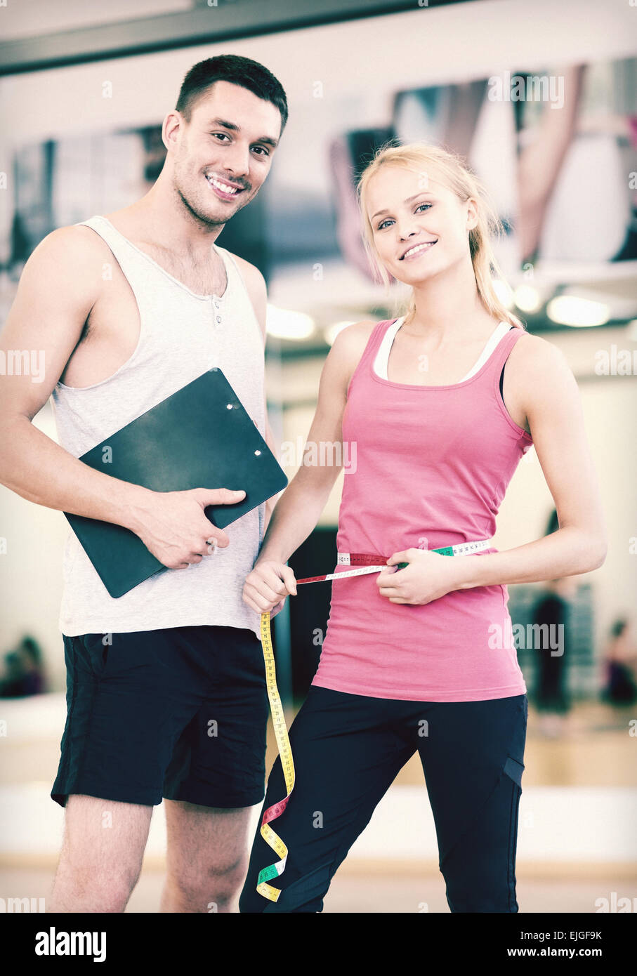 two smiling people with clipboard and measure tape Stock Photo