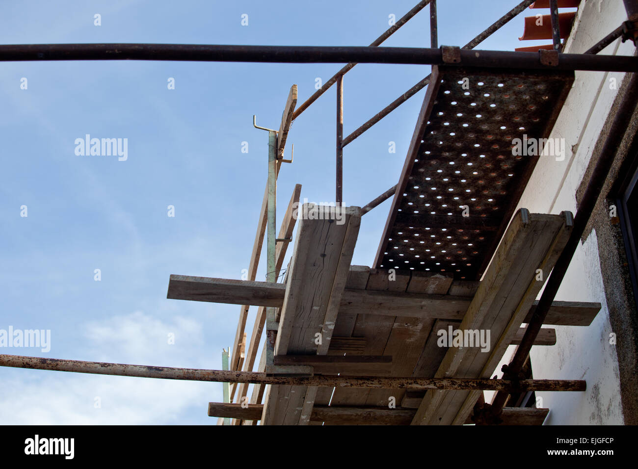 Rural building facade under reconstruction with old scaffoldings Stock Photo